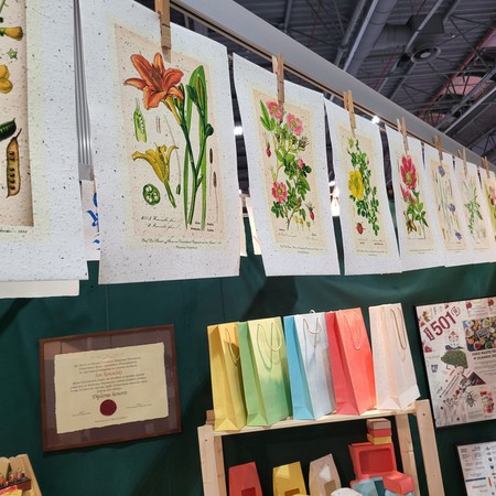 Botaniczne plakaty na papierze czerpanym i torebki z papieru na stoisku targowym