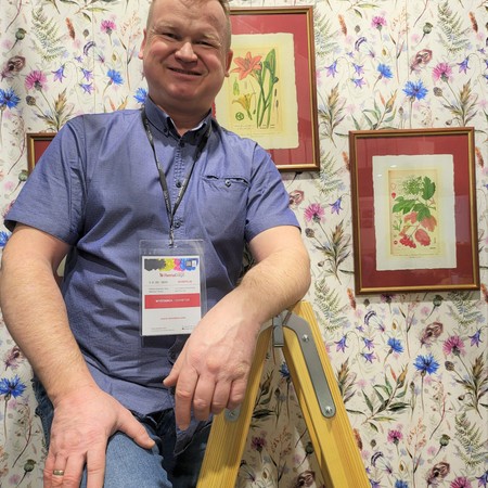 Flawiusz Pietrzyk z czerpalni ART-PAPIER na tle grafik botanicznych