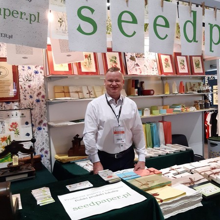 Flawiusz Pietrzyk na stoisku seedpaper.pl z papierem z nasionami na targach