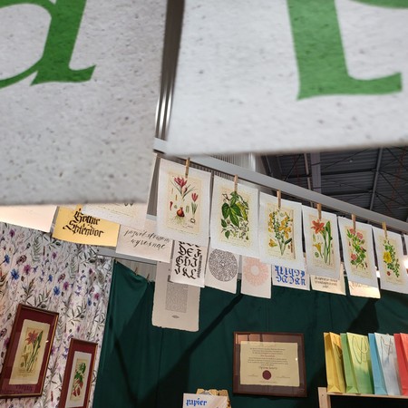 Grafiki botaniczne na papierze czerpanym zawieszone nad stoiskiem ART-PAPIER