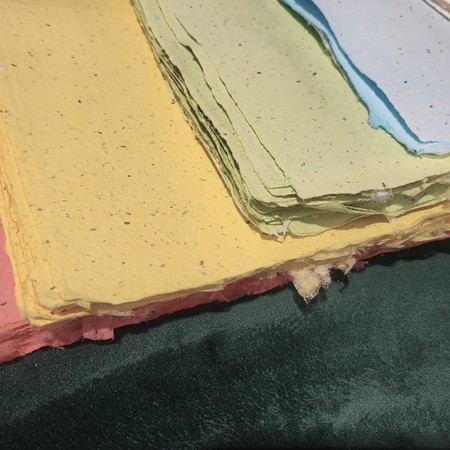 Deckled edges of colourful handmade paper in a stack