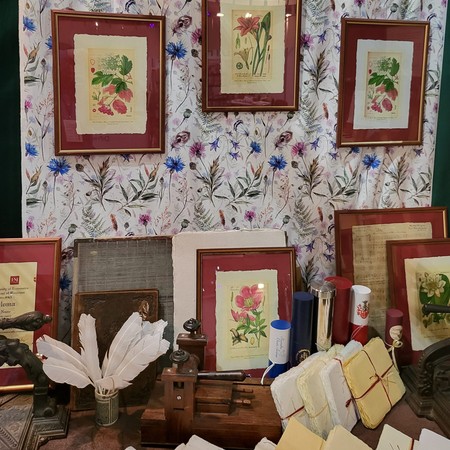 Botaniczne grafiki w ramach i ryzy papieru czerpanego na stoisku ART-PAPIER