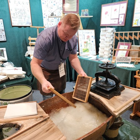 Flawiusz Pietrzyk making paper during a demonstration at the ART-PAPIER trade fair stand
