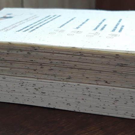 Stos zadrukowanych kartek A5 z papieru rosnącego – widoczne nasiona na brzegach