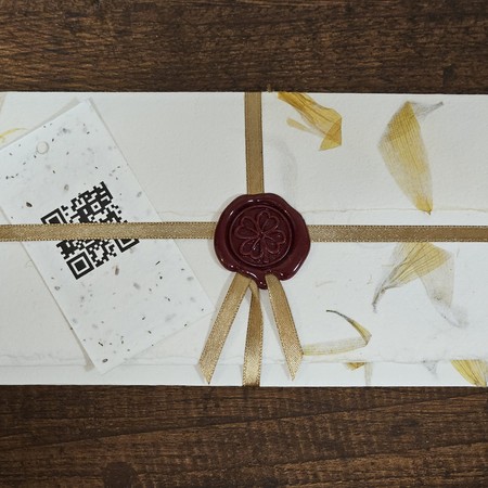 Zawieszka z kodem QR na kopercie z papieru czerpanego z pieczęcią lakową i złotą wstążką